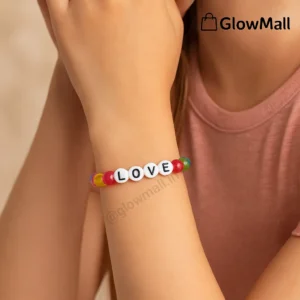 A person's wrist wearing a colorful beaded Glow Mall bracelet with white circular beads spelling out the word 'LOVE'.
