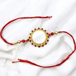A blank personalized Rakhi from Glow Mall with an ornate red jewelled and golden frame, with a white center ready for photo customization.