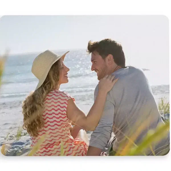 A personalized mousepad from Glow Mall featuring a romantic photo of a couple, sitting on a wooden desk with a computer mouse.